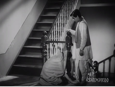 Chandramukhi, overwhelmed by the occasion, touches the feet of Devdas.